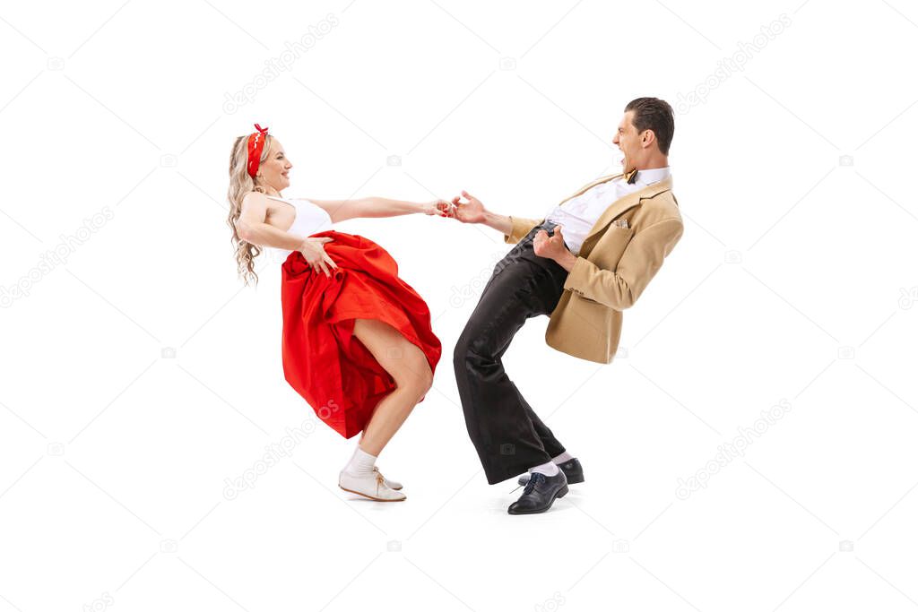Music and dance. Astonished young man and woman in retro style outfits dancing lindy hop isolated on white background. Timeless traditions, 60s ,70s american fashion style. Emotions, expressions