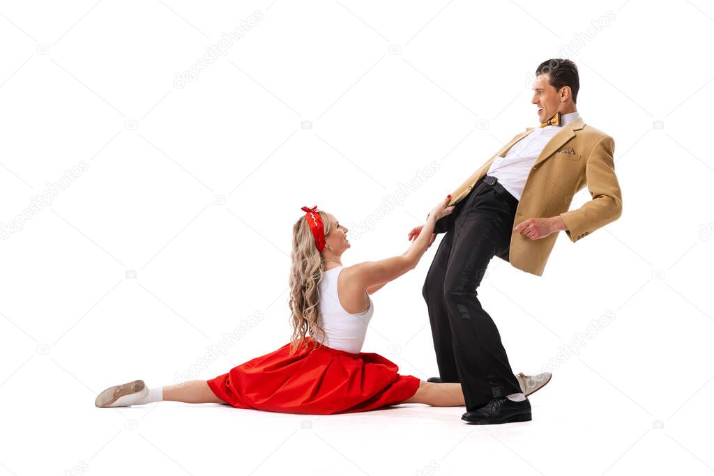 Music and dance. Astonished young man and woman in retro style outfits dancing lindy hop isolated on white background. Timeless traditions, 60s ,70s american fashion style. Emotions, expressions