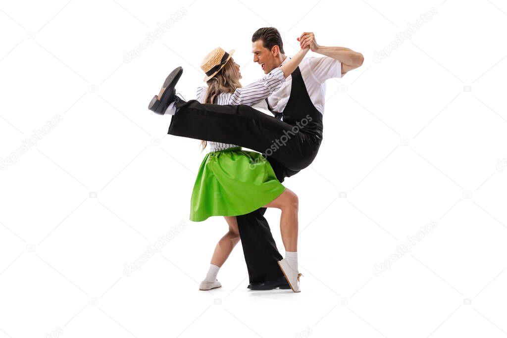 Music and dance. Astonished young man and woman in retro style outfits dancing lindy hop isolated on white background. Timeless traditions, 60s ,70s american fashion style. Emotions, expressions
