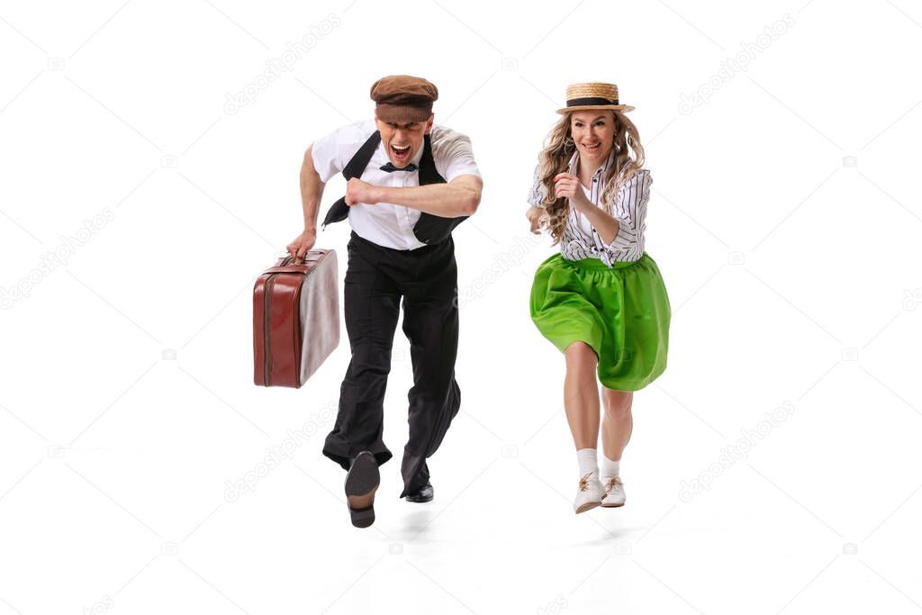 Music and dance. Astonished young man and woman in retro style outfits dancing lindy hop isolated on white background. Timeless traditions, 60s ,70s american fashion style. Emotions, expressions