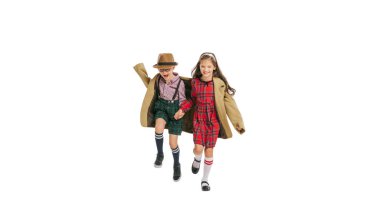 Atlıyorum. Eğleniyorum. Mutlu küçük kız ve oğlan, çekici çocuklar eski moda kıyafetler, 70 'ler, 80' ler modası beyaz stüdyo arka planında izole edilmiş, reklam için fotokopi alanı var..