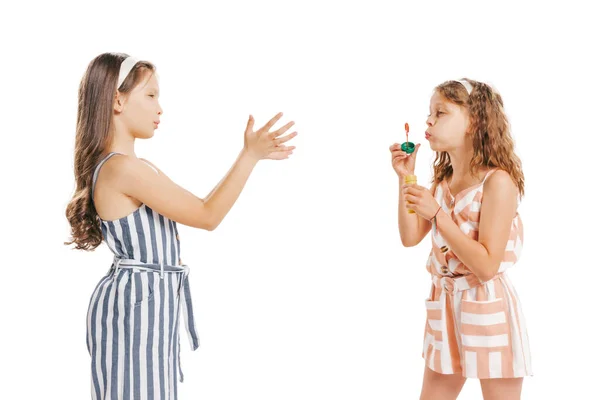 泡吹きをしてる 白い背景に隔離されたレトロなスタイルの夏服の2人の陽気な女の子 子供の感情 顔の表情 美しさ 子供時代の概念 広告のコピースペース — ストック写真