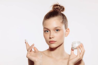 İyi korunmuş deri. Beyaz arka planda, makyajsız genç ve güzel bir kadın modelin yarım boy portresi. Güzellik, kaplıca, masaj, yüz gerdirme ve cilt bakımı