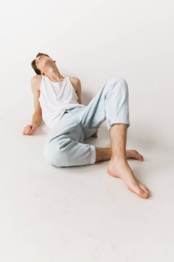 Beyaz stüdyo arka planında izole edilmiş yakışıklı beyaz adam portresi. Moda anlayışı, gençlik, duygular, yüz ifadesi, reklam. Moda erkek modelleri gündelik kıyafetlerle poz veriyor. Sakin görünüyor.