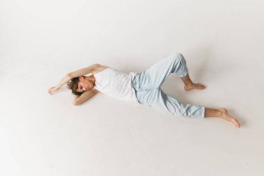 Duygular. Genç, yakışıklı bir adamın havadan görünüşü, beyaz arka planda izole edilmiş günlük kıyafetler giyen bir öğrenci. Sanat, güzellik, moda, gençlik kültürü, satış ve reklamlar