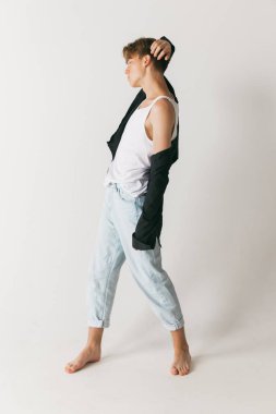 Genç bir adamın portresi, beyaz stüdyo arka planında izole edilmiş bir öğrenci pozu. Günlük kıyafetlerle modacı erkek manken. Sanat, güzellik, moda, gençlik kültürü, satış ve reklamlar