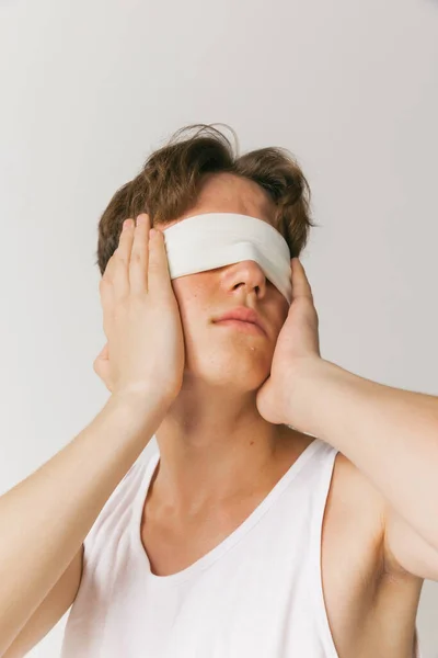 Obscurity. Handsome man with blindfold isolated on white studio background. Concept of fashion, youth, emotions, facial expression, ad. Fashion male model in casual style clothes posing.