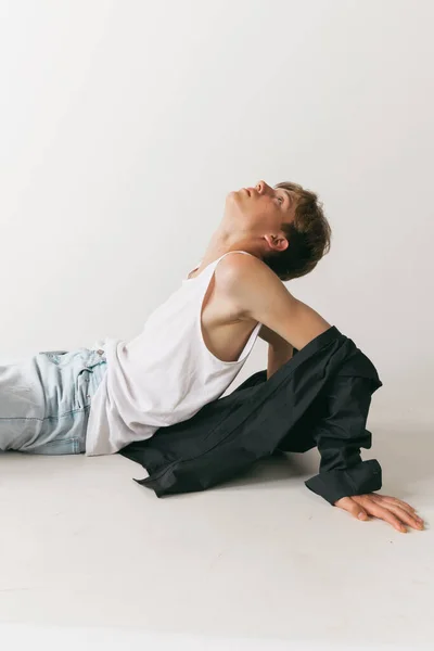 Despair. Portrait of young man, teen, student posing isolated over white studio background. Fashion male model in casual style clothes. Concept of art, beauty, fashion, youth culture, sales and ads