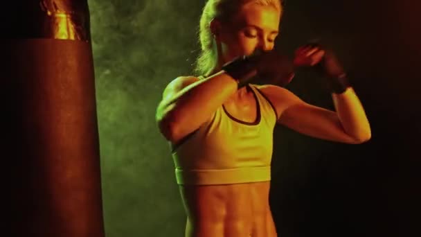 钢制腹肌成就 活泼的女人 女性职业拳击手在霓虹灯下的黑烟熏健身房接受训练 能源概念 妇女参与体育 — 图库视频影像