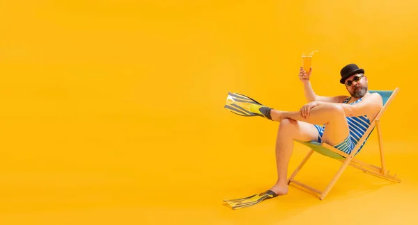 身穿老式条纹泳衣 头戴圆顶礼帽的胖男人 身穿可笑的泳衣 头戴黄色背景的日光浴床 休闲活动 广告的复制空间 — 图库照片