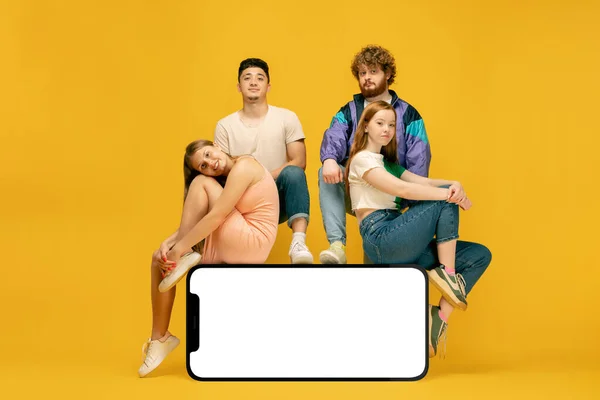 Group Young People Standing Sitting Huge Model Smartphone Empty White — Stock Photo, Image