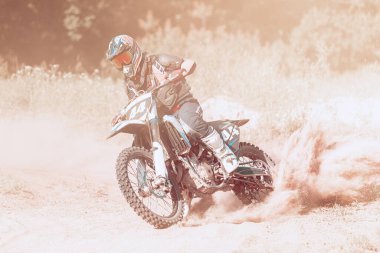 Sıcak yaz gününde, açık havada motosikletli erkek sporcu eğitiminde canlı çekim. Motokros binicisi iş başında. Motokros sporu, rekabet, erkek hobisi, hız, güç, enerji ve reklam