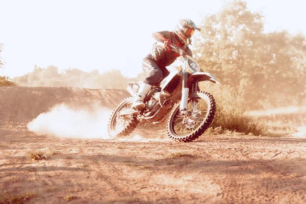 Speed and power. Live shot of male sportsman training on motorbike at hot summer day, outdoors. Motocross rider in action. Motocross sport, competition, male hobby, energy and ad