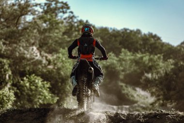 Enduro motosikleti süren Ukraynalı profesyonel motosikletçi, sıcak yaz gününde açık havada. Motokros sporu, hız, motor. 11 Haziran 2022