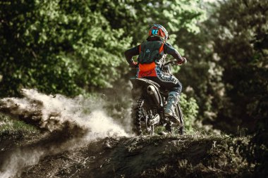 Orman yolu, yol. Profesyonel motosiklet sürücüsünün yarışma sırasında Enduro motosikletine binerken canlı çekimi, yaz akşamları açık havada. Motokros sporu, hız, aksiyon