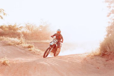 Professional motorcycle rider training on Enduro motorcycle at steppe or desert area, outdoors at hot summer day. Motocross sport, speed, action clipart