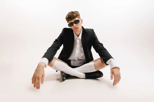 Portrait of young stylish man, student posing isolated over white studio background. Fashion male model in urban business style clothes. Concept of art, beauty, fashion, youth culture, sales and ads
