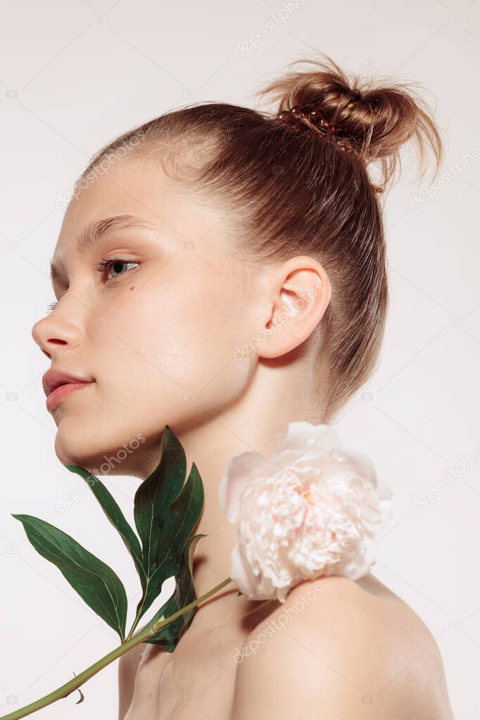 Beauty portrait of charm young girl with flower isolated over white studio background. Spa, skincare and medicine, cosmetics, natural beauty and aesthetic cosmetology concept. Copy space for