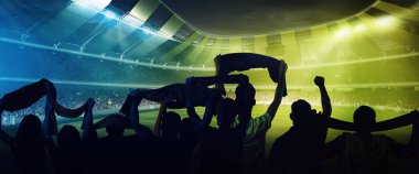 Dünya Kupası 'nda. Futbolun arka planı, futbol taraftarlarının akşam vakti kalabalık stadyumda eşarplarıyla takımlarını alkışlamaları. Spor, kupa, dünya, takım, etkinlik, yarışma kavramı. Mavi, yeşil, sarı