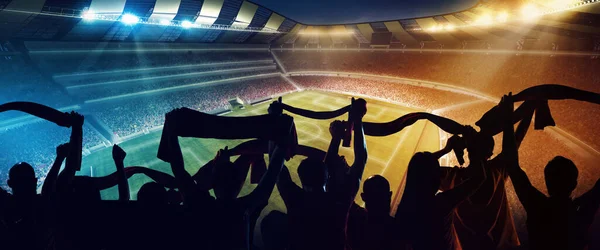 Group of people silhouettes. Back view of football, soccer fans cheering their team with and scarfs at crowded stadium at evening time. Concept of sport, cup, world, team, event, competition