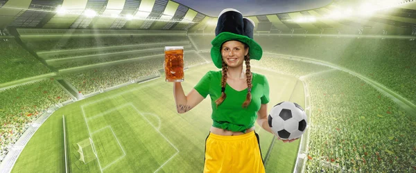 Happy excited woman in green yellow football kit holding beer mug and football ball supports favorite team. Emotions, drinks, hobby, fans, competition, sport, oktoberfest concept. St. Patricks Day