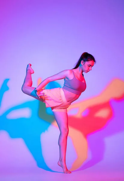 Tańcząca Młoda Dziewczyna Sportowym Mundurze Ćwicząca Gradientowym Tle Studia Neonowym — Zdjęcie stockowe
