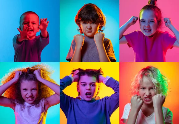 Angry. Childrens emotions. Set of portraits of little cute kids, boys and girls isolated on multicolored background in neon light. Education, wow emotions, facial expression and childhood concept.