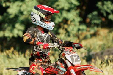 Dnipro, Ukrayna 01 Temmuz 2022. Ukraynalı acemi motosikletçi Enduro motosikleti kullanıyor, sıcak yaz gününde açık havada. Çocuklar motokros eğitimi