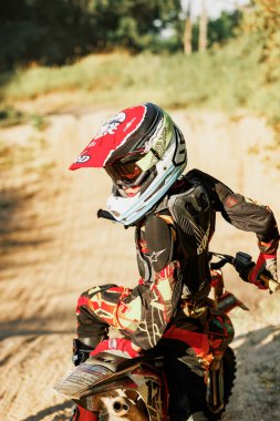 Dnipro, Ukraine JULY 01, 2022. Ukrainian beginner motorcycle rider driving on Enduro motorbike, outdoors at hot summer day. Kids motocross training