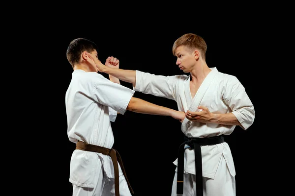 Karate Dövüşü Spor Üniformalı Iki Erkek Karatedo Dövüşçüsü Siyah Arka — Stok fotoğraf