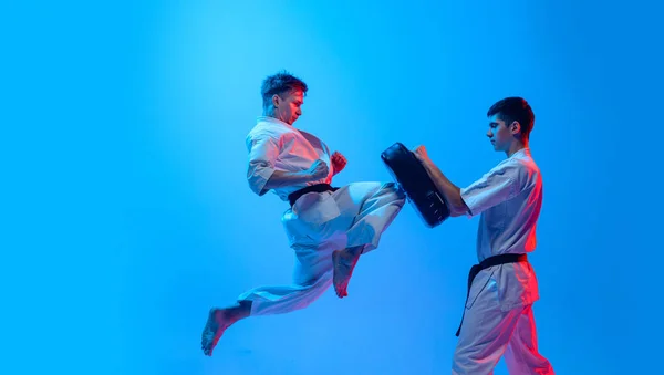 Studio Shot Sports Training Two Karatedo Fighters Doboks Isolated Blue — Φωτογραφία Αρχείου