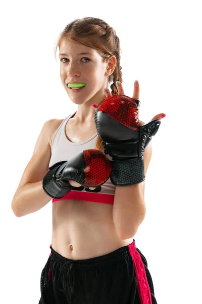 Win. Champion, combat sport. Female junior MMA fighter in sports uniform training isolated on white background. Concept of sport, competition, action, health. Copy space for ad.