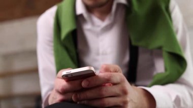 Portrait of young smiling man using phone, chatting. Concept of emotions, online services, new apps, social media, choosing goods and services. Video, 4k. Unfocused effect