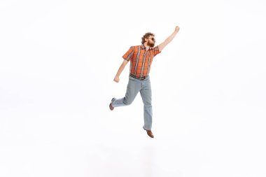 Running. Portrait of young man dressed in 50s, 60s fashion style outfit posing isolated on white background. Concept of modern culture, beauty and ad. Cyclical fashion. Copy space for ad