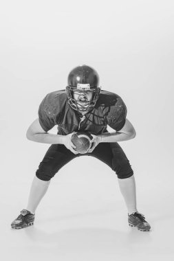 Hand-eye coordination. Retro styled portrait of american football player in vintage sports uniform isolated on white background. Concept of sport, eras comparison, timeless traditions, skills and ad