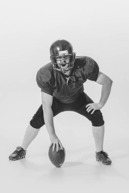 Start game. Strong american football player in vintage style sports uniform isolated on white background. Concept of sport, eras comparison, timeless traditions, skills and ad