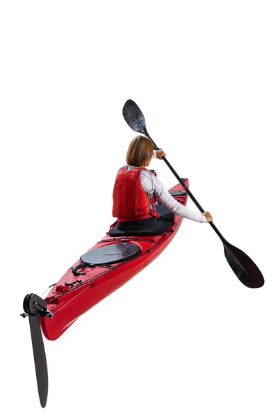 Back view. Young woman, sportsman in red canoe, kayak with a life vest and a paddle isolated on white background. Concept of sport, nature, travel, active lifestyle