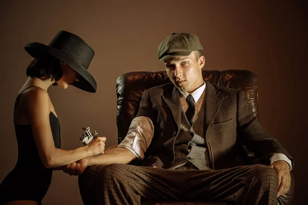 Beauty. Vintage style portrait of man and woman in 1920s style fashion outfits isolated over dark brown background. Concept of business, personality, emotions, family, art, fashion