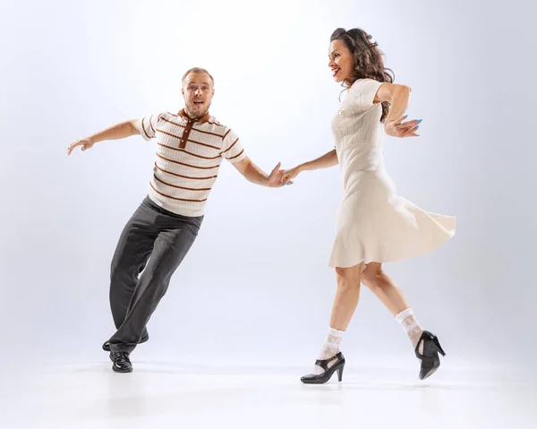 Delight. Astonished young dancing man and woman dance sport dances isolated on white background. Timeless traditions, 60s ,70s american fashion style.