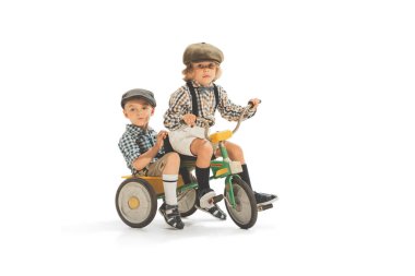 Cute happy kid riding tricycle isolated on white studio background. Retro vintage style concept. Friendship, hobbies, art, eras comparison and children emotions