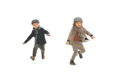 Catch-up. Two preschool age boys, fashionable kids wearing autumn retro clothes strolling isolated over white background. Concept of childhood, vintage summer fashion style. Copy space for ad