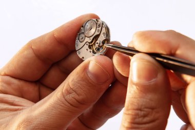 Restoration, repair. Closeup watchmakers hands repairing mechanical watches isolated over white background. Concept of vintage retro mechanisms, job, work, ad