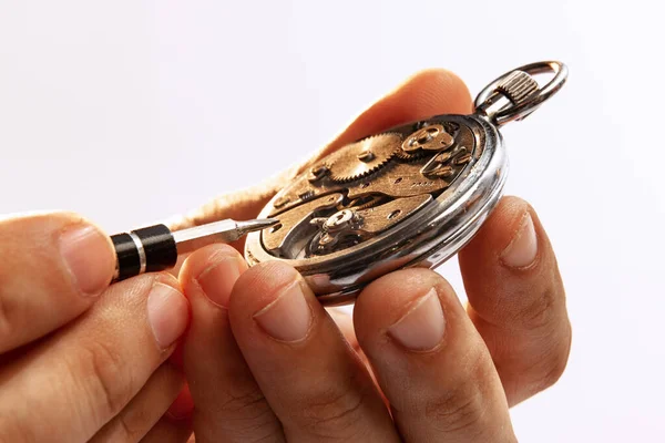 Watchmakers job. Closeup male hands repairing mechanical watches isolated over white background. Concept of vintage retro mechanisms, job, work, ad