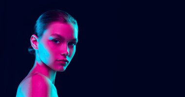 Charm, flirt. Young beautiful girl with well-kept skin and without makeup isolated over dark background in neon light. Concept of natural beauty, art, emotions, cosmetics and youth. Flyer for ad