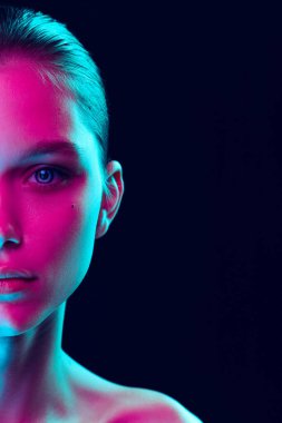 Blue eyes. Close up eyes of beautiful young girl looking camera in pink neon light. Concept of cosmetics, makeup, natural and eco treatment, skin care. Shiny and healthy look, fashion, vision. Details
