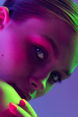 Blue eyes. Close up eyes of beautiful young girl looking away in pink neon light. Concept of cosmetics, makeup, natural and eco treatment, skin care. Shiny and healthy look, fashion, vision. Details.