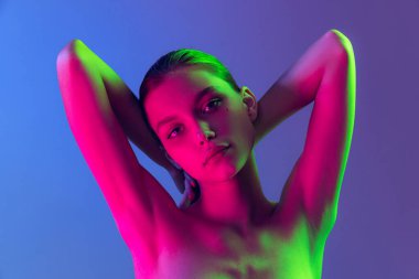 Femininity and softness. Portrait of young, beautiful and healthy girl with well-kept skin isolated on dark background in neon light. Art, fashion, style, facial expression, eco products and health