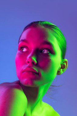 Night life. Young adorable sad girl posing isolated over blue background in neon light. Concept of natural beauty, art, emotions, cosmetics and youth. Flyer for ad. Looks calm