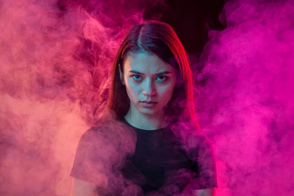 Annoyed young dark hair woman with different emotions isolated over pink background with clouds of smoke. Concept of mental health, art, human emotions, challenges, ad