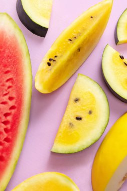 Summer colors. Top view of ripe juicy red and yellow watermelon slices over colorful background. Design for wallpaper, greeting season card, ad, sales. Vitamins, berries. Closeup.